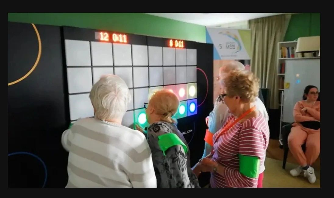 Résidentes participant à une animation IMPACTO SENIOR autour du mur interactif
