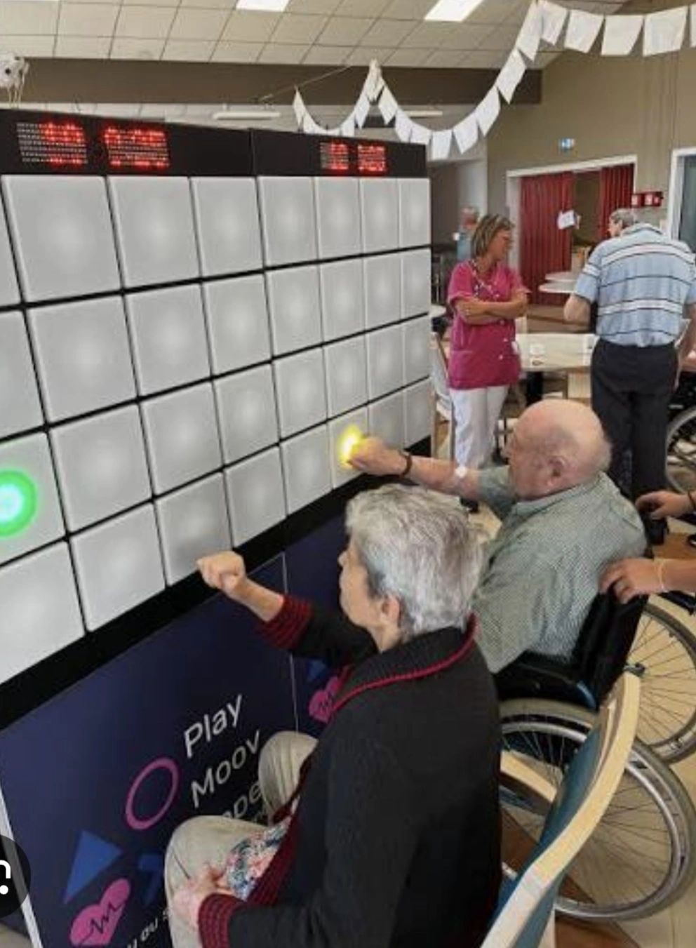 Participants seniors dont une personne en fauteuil utilisant le mur interactif IMPACTO